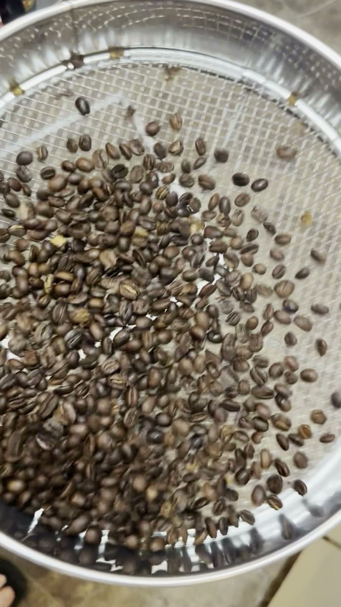 焙煎後の豆をザルに空けたところ。チャフは網目から落ちる（Snowman Coffee Roasters）